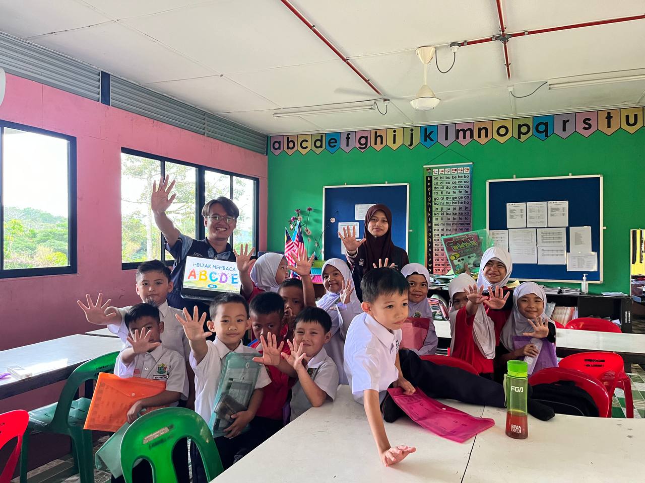 A YSS volunteer teaching school children in an i-Bijak Membaca literacy class